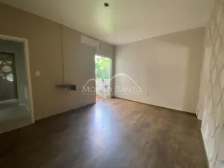 Ambiente interno com piso de madeira escura e paredes claras.