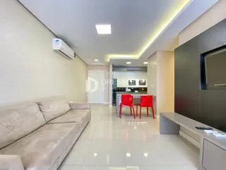 Sala de estar com sofá e piso claro em um imóvel.