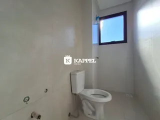 Banheiro com revestimento branco e vaso sanitário instalado.