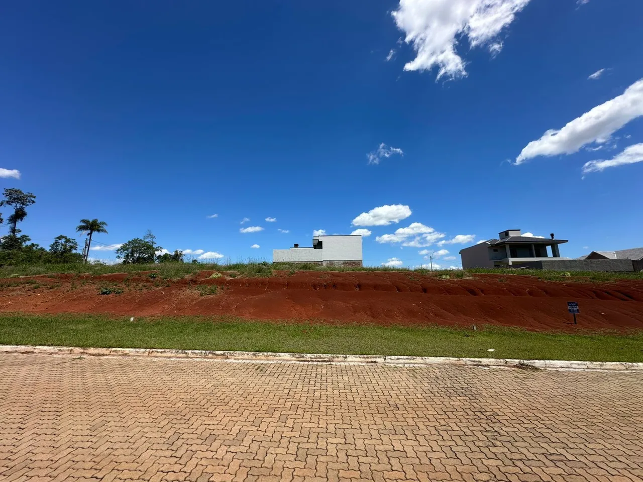 Vista externa de uma residência em um ambiente aberto com terreno avermelhado.