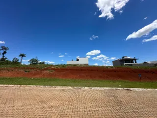 Vista externa de uma residência em um ambiente aberto com terreno avermelhado.