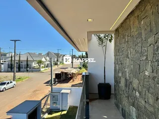 Vista externa de uma área com muro de pedra e paisagismo.