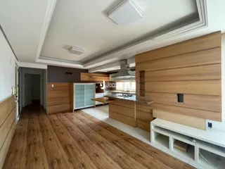 Cozinha moderna com armários de madeira e piso de madeira clara.