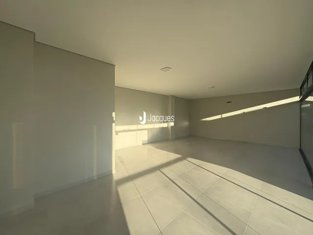 Espaço interno de uma residência com piso de cerâmica e paredes brancas.