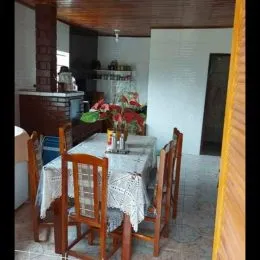 Foto de uma sala de jantar com mesa de madeira e cadeiras.