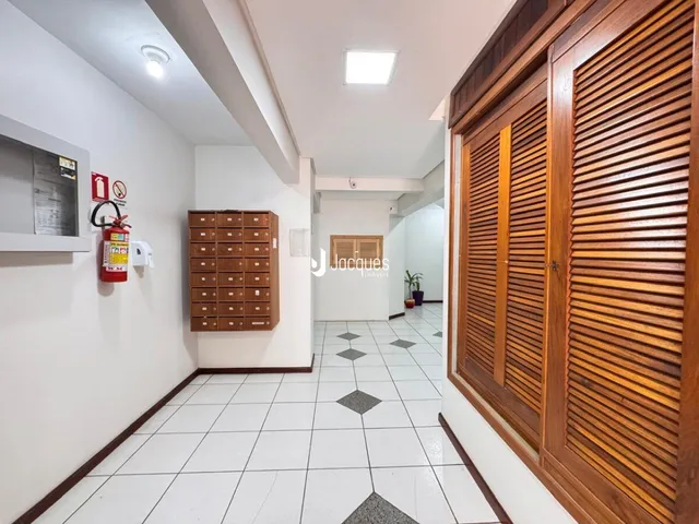 Corredor interno com piso de cerâmica e painéis de madeira.