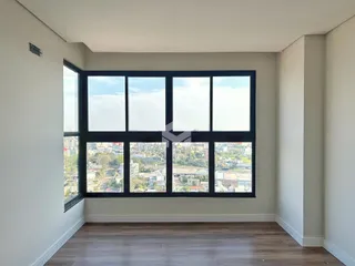 Ambiente interno com grande janela que oferece vista da cidade.