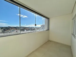 Sala com grande janela oferecendo vista da paisagem urbana.