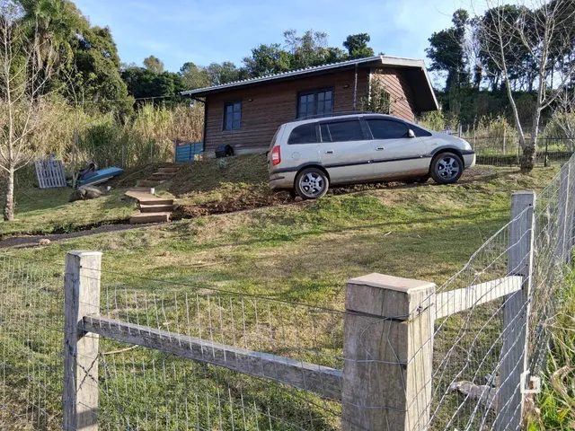 Vista da fachada de uma casa em Lajeado, Brasil, com jardim e cerca de madeira.