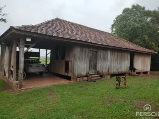 Fachada de uma casa rústica de madeira com telhado inclinado.