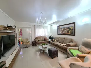 Sala de estar com sofás e piso de cerâmica em uma residência.