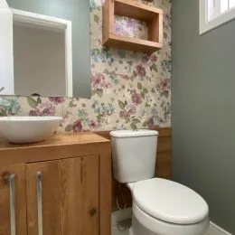 Foto de um banheiro mostrando um vaso sanitário e armários de madeira.