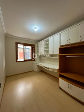 Sala de estar com piso de madeira clara e armários embutidos.