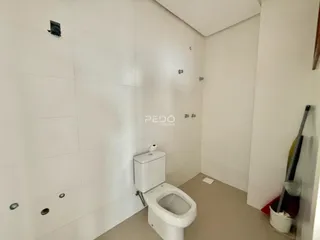 Foto de um banheiro interno com paredes brancas e piso claro.