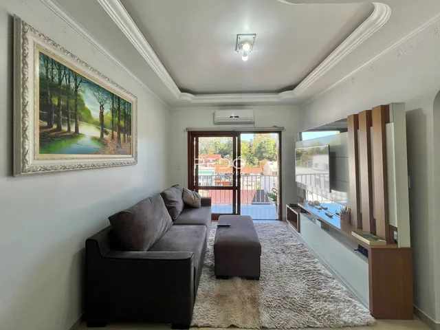 Sala de estar com sofá e televisão em um apartamento no Brasil.