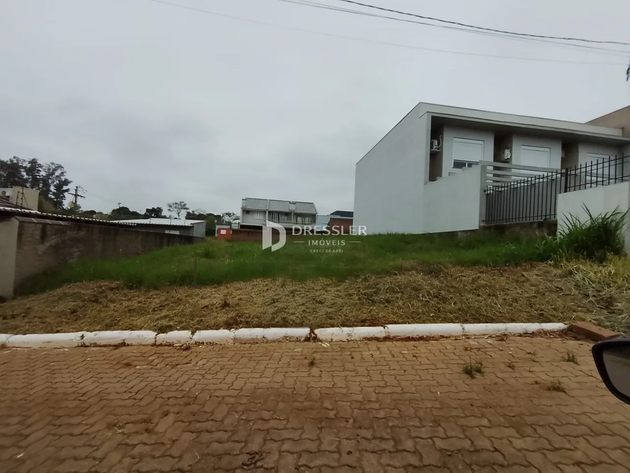 Vista externa de uma residência em Lajeado, Brasil, com cerca e vegetação seca.