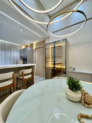 Foto de um ambiente interno com mesa de jantar e iluminação moderna.