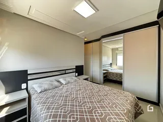 Quarto com cama e armários em um imóvel.