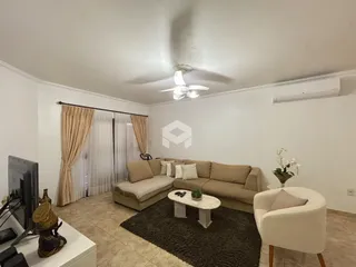 Sala de estar com sofá e cortinas claras.