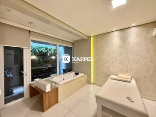 Foto de um banheiro com banheira e vista para o exterior.