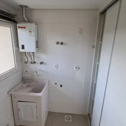 Foto de um banheiro interno com pia e armário branco.