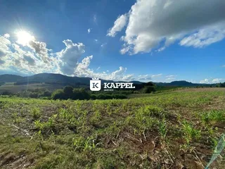 Vista panorâmica de um campo aberto com colinas ao fundo.