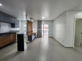 Ambiente moderno de sala de jantar e cozinha com piso de cerâmica clara.