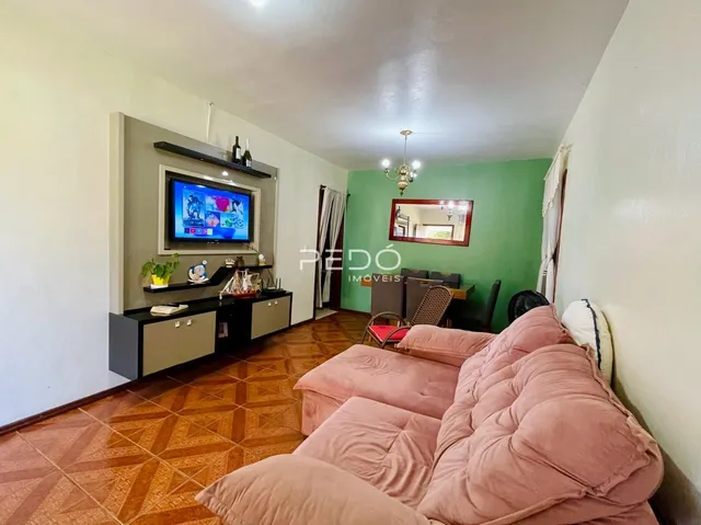 Sala de estar com sofá e televisão em ambiente interno.