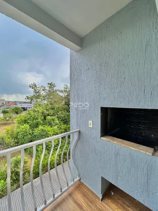 Vista da varanda de um imóvel em Lajeado, Brasil, com grade de metal e vista para a vegetação.