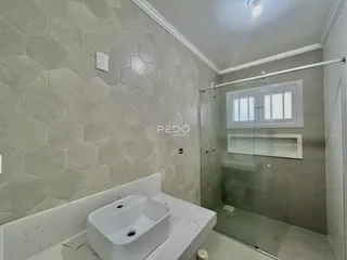 Foto de um banheiro com revestimento hexagonal e box de vidro.
