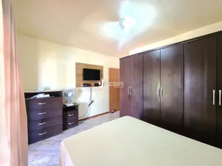 Quarto com cama e armários de madeira no interior da residência.