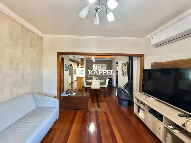 Sala de estar com sofá branco e piso de madeira.