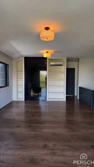 Foto de um corredor interno com piso de madeira escura e nichos brancos.