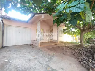 Fachada de uma residência em Lajeado, Brasil, com vegetação na frente.