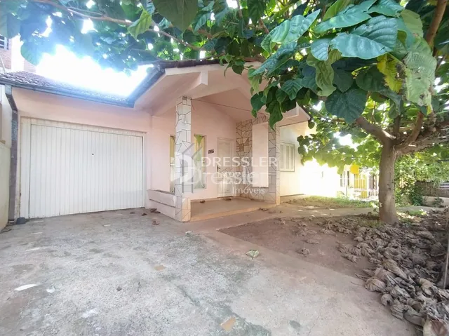 Fachada de uma residência em Lajeado, Brasil, com vegetação na frente.