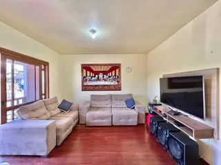 Sala de estar com dois sofás e piso de madeira no imóvel.