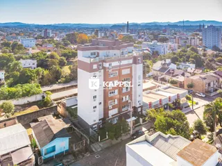 Vista aérea de um complexo residencial em Lajeado, Brasil, com edifícios e vegetação circundantes.