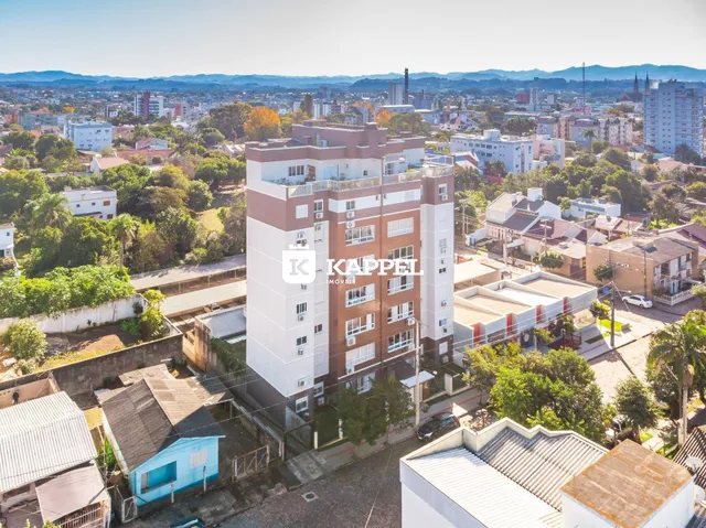Vista aérea de um complexo residencial em Lajeado, Brasil, com edifícios e vegetação circundantes.