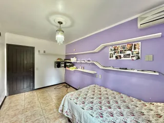 Quarto com paredes roxas e piso de cerâmica.