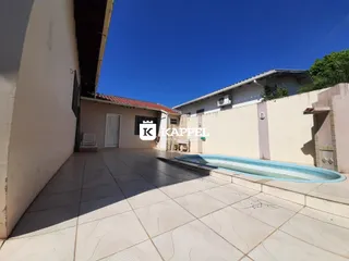 Foto externa mostrando uma piscina e área de piso cerâmico em uma residência.