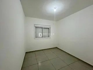 Foto de um cômodo interno com paredes brancas e piso de cerâmica.