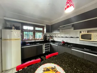 Foto de uma cozinha moderna com armários escuros e bancada escura.