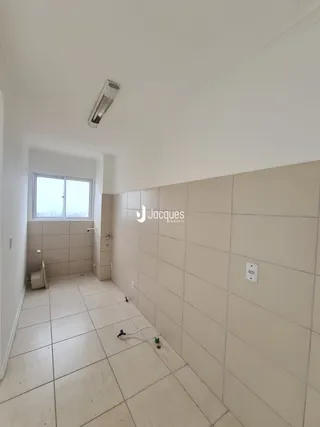 A foto mostra um corredor interno com piso de cerâmica e paredes claras.