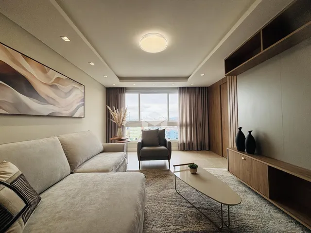 Sala de estar moderna com grande janela e decoração contemporânea.