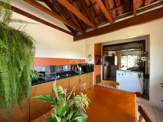 Interior da cozinha com armários de madeira e vigas de madeira.