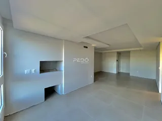 Ambiente interno de uma sala ampla com paredes brancas e piso claro.