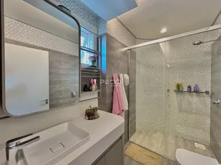 Foto de um banheiro moderno com box de vidro e revestimento cerâmico.