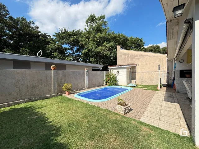 Vista externa de uma piscina e jardim de uma propriedade em Lajeado.
