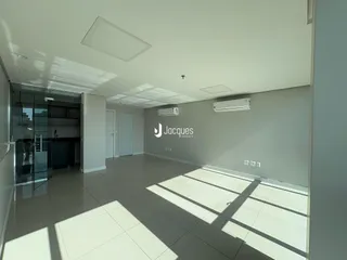 Sala de estar com piso claro e paredes brancas em um imóvel.