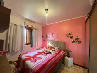 Quarto com parede rosa e cama grande em um imóvel no Brasil.